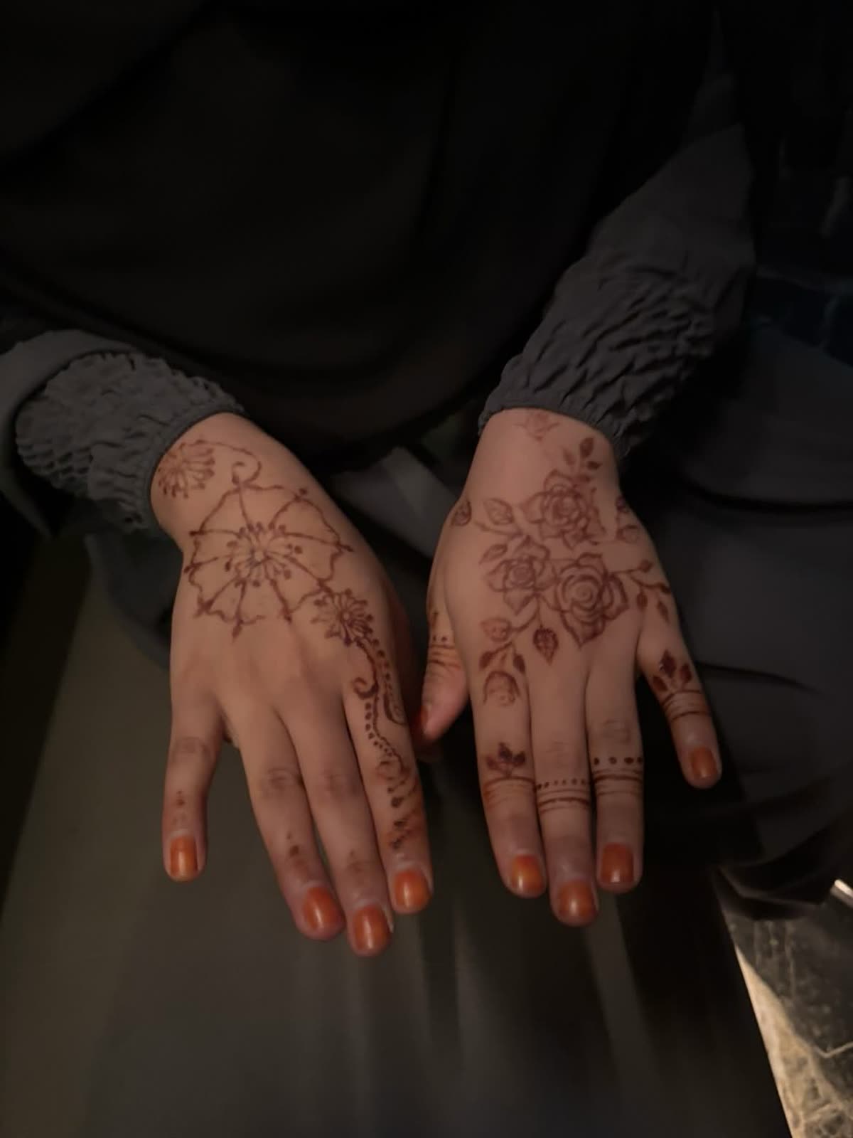 Natural henna across both hands — a central mandala with trailing roses
